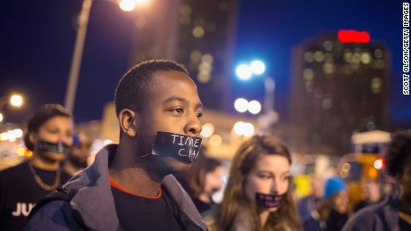 A protestor with a taped mouth marches through downtown St. Louis on March 14. 