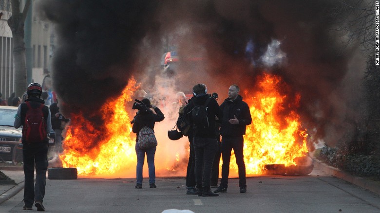 Firefighters try to extinguish burning barricades on the opening day of the European Central Bank (ECB) headquarters in Frankfurt, Germany, on March 18.