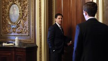 Rubio speaks to an aide on Capitol Hill as he arrives for the weekly Senate Republican Policy Committee luncheon in September 2013.