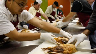 SAN FRANCISCO - NOVEMBER 21:  Volunteers carve freshly roasted turkeys at St. Anthony's Dining Room November 21, 2007 in San Francisco, California. Volunteers helped carve over 4,800 pounds of turkey and prepared thousands of mini pumpkin pies to be served to needy and homeless people on Thanksgiving day.  (Photo by Justin Sullivan/Getty Images) 