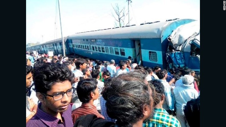 A crowd watches as emergency workers help victims of a passenger train derailment in India&#39;s Uttar Pradesh state on Friday.