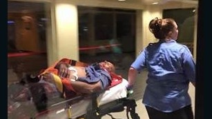 The suspect in the attack on TSA agents at the New Orleans-area airport is taken away on a stretcher.