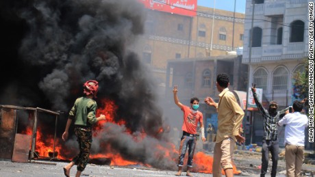 Yemenis stand in front of burning tires during an anti-Houthi protest in Taiz, Yemen, on Tuesday, March 24. 