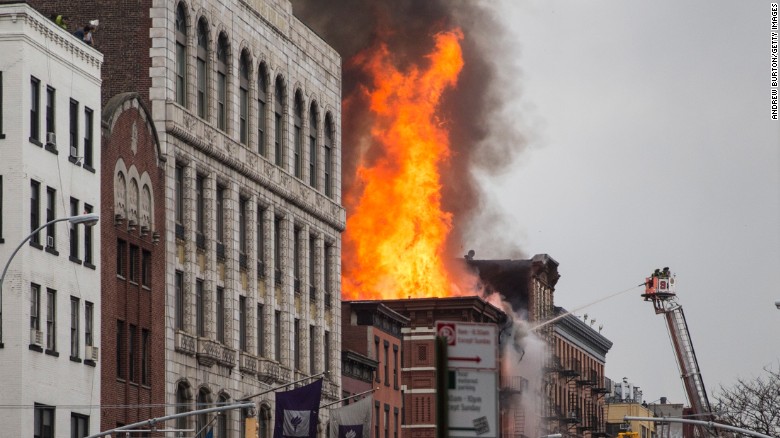 Flames can be seen coming from the building's roof. 