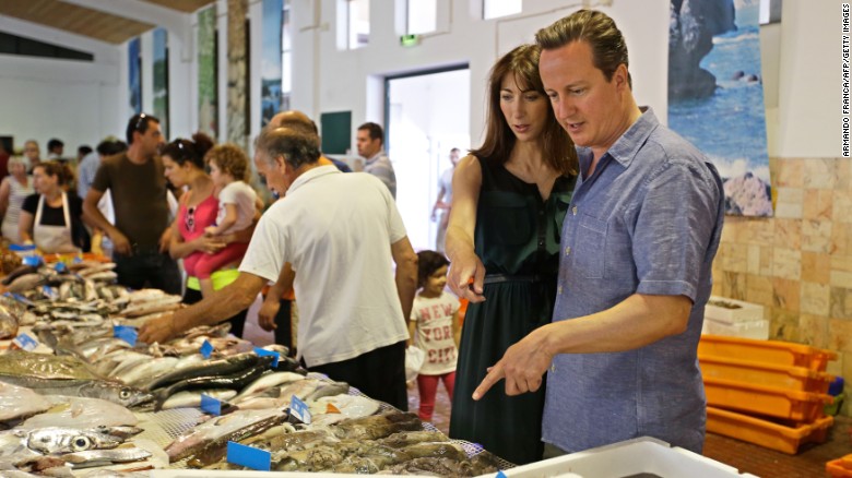 British Prime Minister David Cameron points at a fish during a visit to a fish market while on holiday in Portugal in 2013.