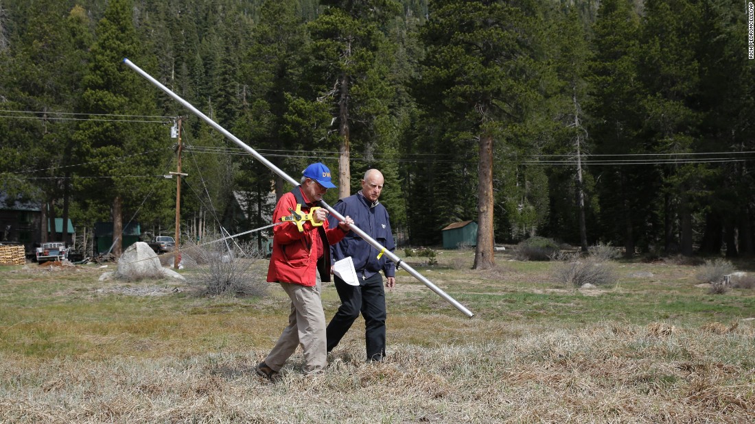 California Gov. Jerry Brown, right, walks with Frank Gehrke, chief of the California Cooperative Snow Surveys Program for the Department of Water Resources, near Echo Summit, California, on Wednesday, April 1. Gehrke said this was the first time since he has been conducting the survey that he found no snow at this location at this time of the year.
