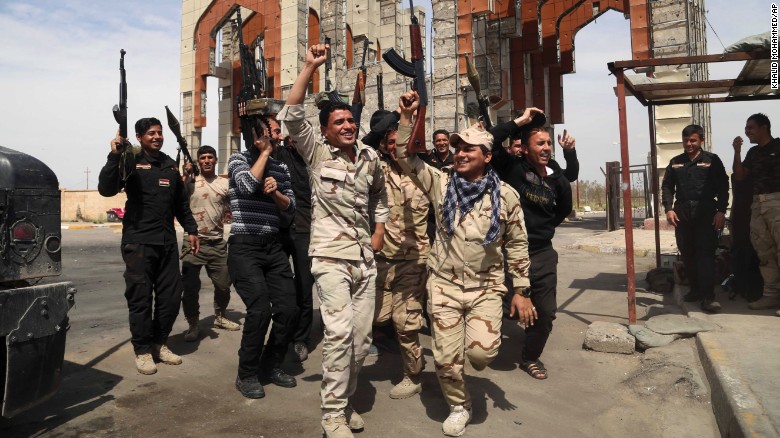 Security forces in Tikrit chant slogans against the ISIS militant group on Friday, April 3. They had just reopened the main gate of their base, which was closed for months while ISIS occupied the city. 