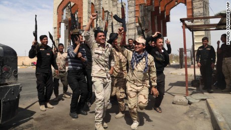 Security forces in Tikrit chant slogans against the ISIS militant group on Friday, April 3. They had just reopened the main gate of their base, which was closed for months while ISIS occupied the city.