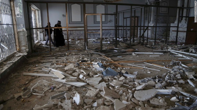 People in Tikrit inspect what used to be a palace of former President Saddam Hussein on April 3.