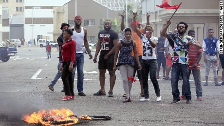 Foreign nationals gesture after clashes broke out between a group of locals and police in Durban on April 14 ,2015 in ongoing violence against foreign nationals in Durban, South Africa. The attacks on immigrant-owned shops and homes in Durban's impoverished townships come three months after a similar spate of attacks on foreign-owned shops in Soweto, near Johannesburg. The Malawian government said on April 13, 2015 it would help repatriate its citizens from South Africa following an outbreak of xenophobic violence in the eastern port city of Durban that has left four people dead.