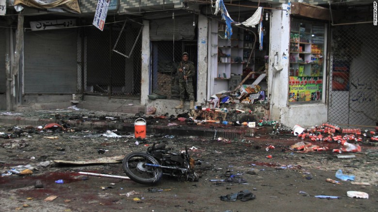 A member of Afghanistan&#39;s security forces stands at the site where a suicide bomber on a motorbike blew himself up in front of the Kabul Bank in Jalalabad, Afghanistan, on April 18.  ISIS claimed responsibility for the attack. The explosion killed at least 33 people and injured more than 100 others, a public health spokesman said.