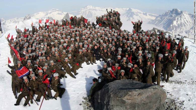 Kim Jong Un, center, poses with soldiers on the snow-covered top of Mount Paektu in an April 18 photo released by South Korean news agency Yonhap.