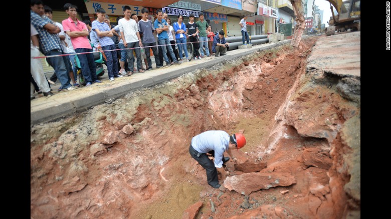 Workers move the fossilized eggs in Heyuan on April 19. They were carrying out road repairs when they found the eggs. 