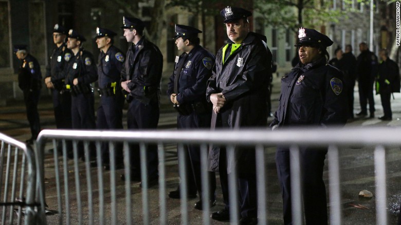 Baltimore Police stand guard behind a barrier outside the Western District station.