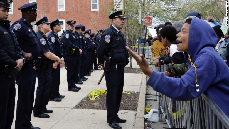 Members of the Baltimore Police Department stand guard Thursday, April 23, outside the department's Western District station during a protest.