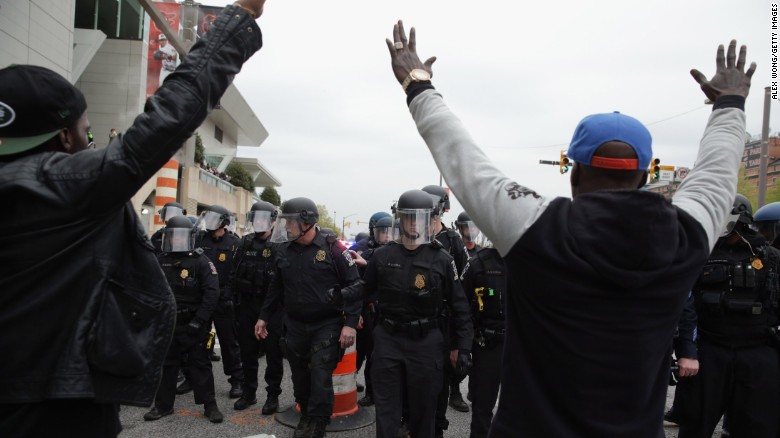 Protesters raise their hands in front of a line of police officers on April 25.