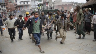Civilian rescuers carry a person on a stretcher in Kathmandu, Nepal, on Saturday, April 25, after a magnitude-7.8 earthquake centered less than 50 miles from Nepal&#39;s capital left widespread destruction and death. 
