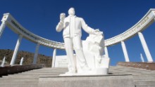 A statue of Turkmenistan's former President Saparmurad Niyazov sits in front of the earthquake memorial in Ashgabat, 13 February 2007. Almost all the brick buildings in Ashgabat, collapsed and 110,000 people were killed when a magnitude-7.3 earthquake struck October 5, 1948.