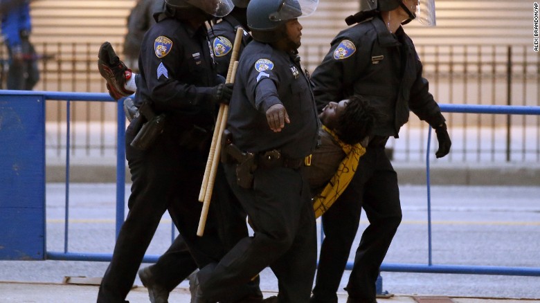 Police carry a detained man to a police van after the march to City Hall on April 25.