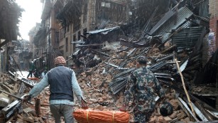 A Nepalese volunteer and a member of the security forces carry tents for distribution on the outskirts of Kathmandu on April 26.