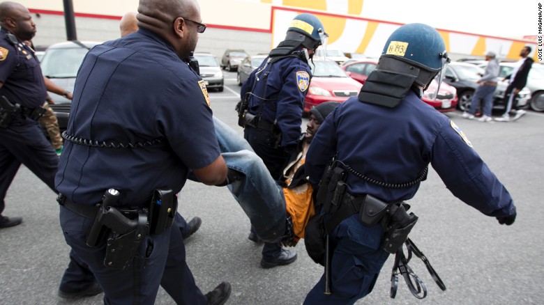 Baltimore police officers detain a demonstrator on April 27.