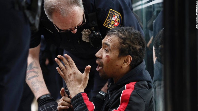 A police officer checks on a man who was injured on April 27.