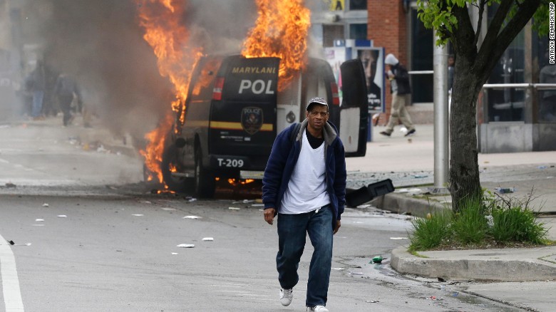 A man walks past a burning police vehicle on April 27.