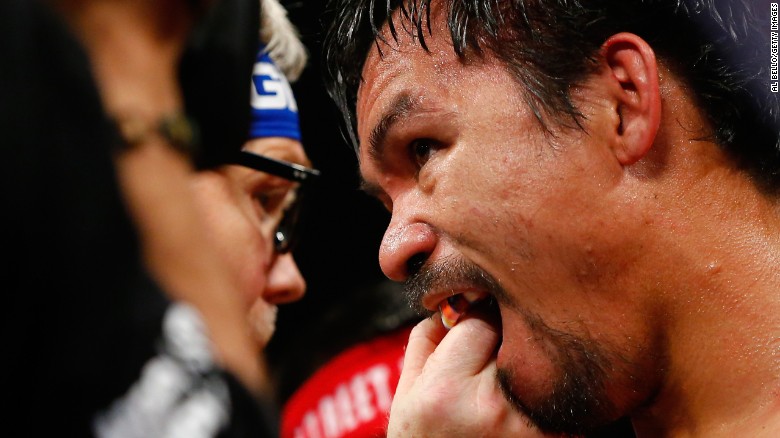 Trainer Freddie Roach adjust Manny Pacquiao's mouthguard.