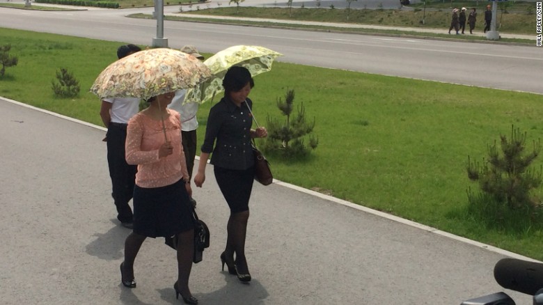 Pyongyang women wear their Sunday best, including ornate umbrellas to shield themselves from the sun.