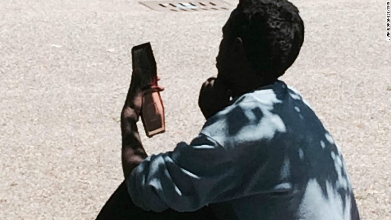 An Eritrean man stares at a cell phone. According to European Union regulations, migrants must be registered in the country they arrive in, and cannot go on to request asylum elsewhere. But many who arrive in Italy flee before they are registered hoping to make it to other European countries. 