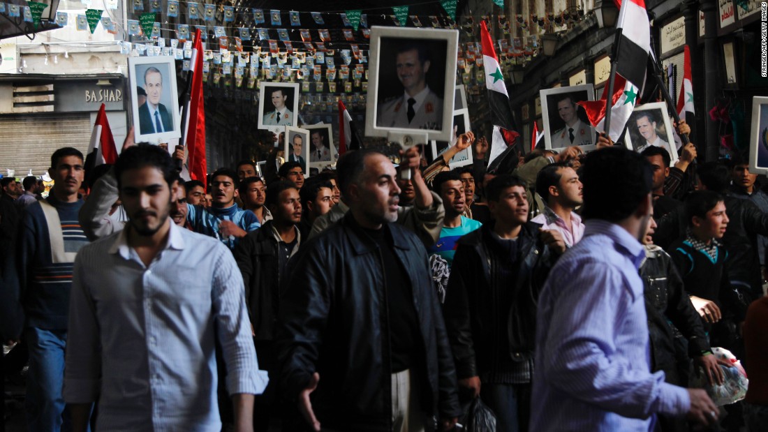 Pro-government protesters hold pictures of Syrian President Bashar al-Assad and his late father, Hafez al-Assad, during a rally in Damascus, Syria, on March 18, 2011. Bashar al-Assad has ruled Syria since 2000, when his father passed away following 30 years in charge. An anti-regime uprising that started in March 2011 has spiraled into civil war. The United Nations estimates more than 220,000 people have been killed.