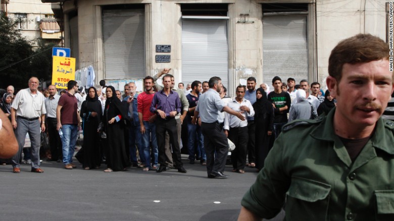 Relatives of Syrian detainees who were arrested for participating in anti-government protests wait in front of a police building in Damascus on October 24, 2012. The Syrian government said it released 290 prisoners.