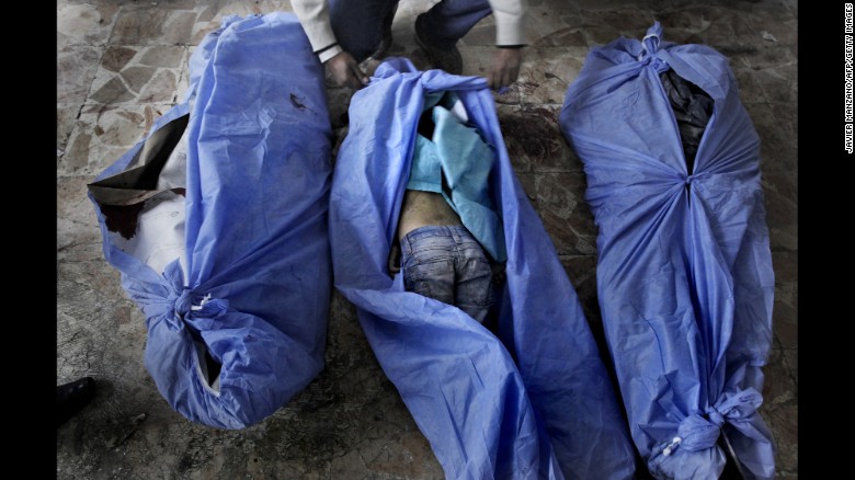 The bodies of three children are laid out for identification by family members at a makeshift hospital in Aleppo on December 2, 2012. The children were allegedly killed in a mortar shell attack that landed close to a bakery in the city.