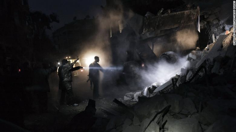 Syrians look for survivors amid the rubble of a building targeted by a missile in the al-Mashhad neighborhood of Aleppo on January 7, 2013.