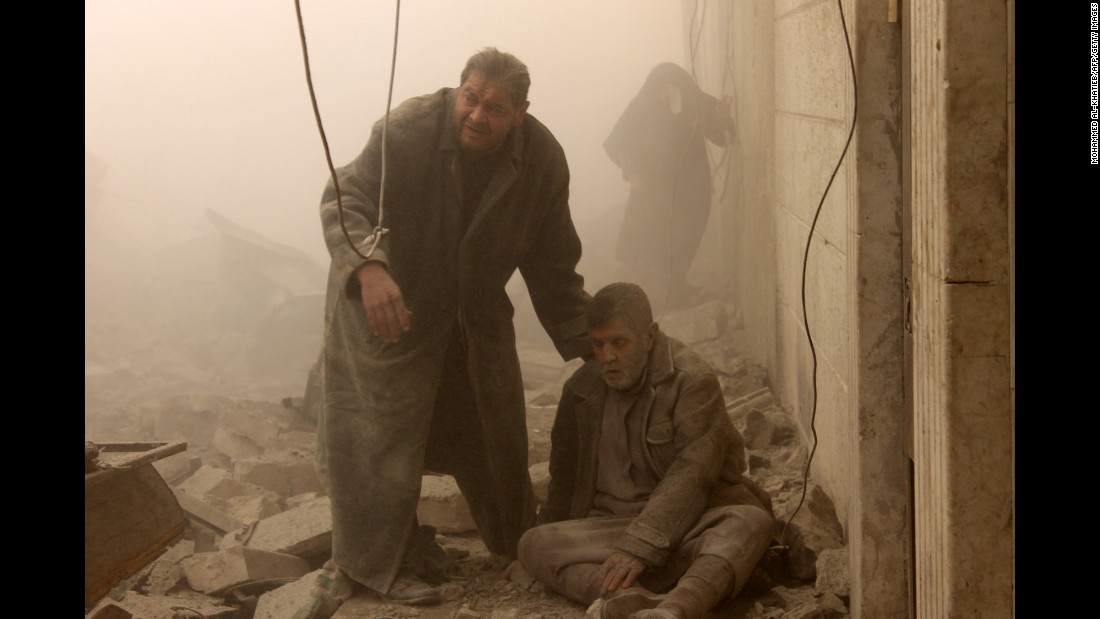 An injured man is helped following an airstrike in Aleppo&#39;s Maadi neighborhood on December 17, 2013.