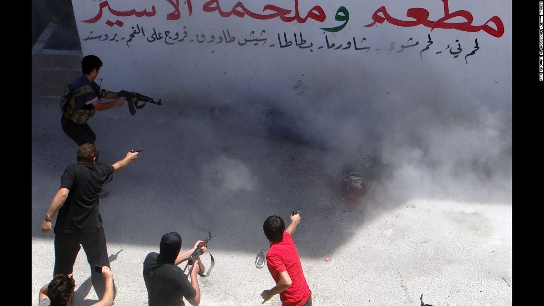 Rebel fighters execute two men on July 25, 2014, in Binnish, Syria. The men were reportedly charged by an Islamic religious court with detonating several car bombs. 