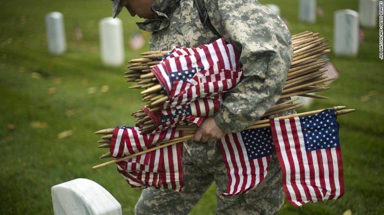 A soldier places flags in Arlington National Cemetery on May 21.