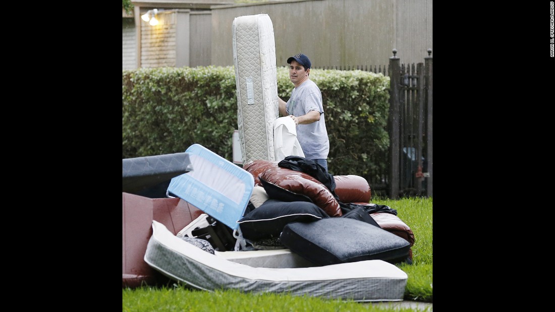 Brian Quattrucci piles flood-damaged debris at the curb in front of a home in the Brays Bayou area of Houston on May 27.