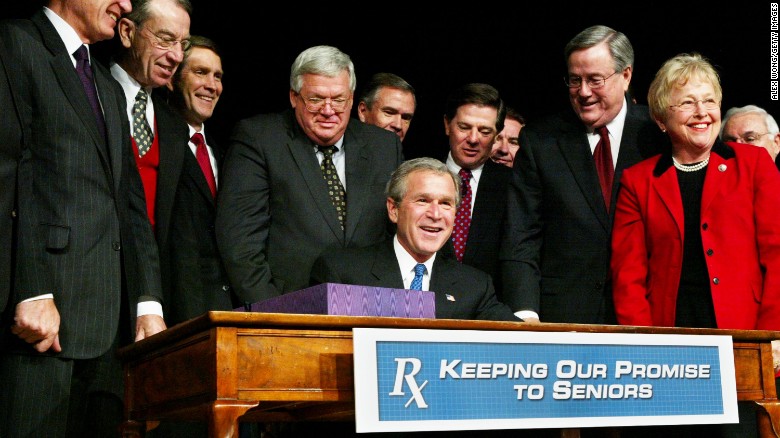 Hastert stands behind President George W. Bush as he signs Medicare legislation in December 2003. Hastert fought hard for the bill in the House, leading to a three-hour vote on November 22, 2003. 
