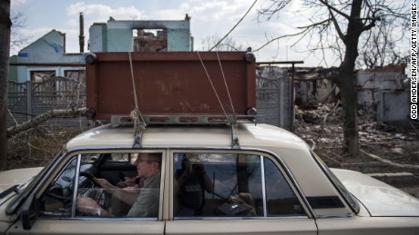 Residents flee with salvaged belongings during renewed fighting in the Jabunki neighborhood near the airport in Donetsk on Monday, April 13.