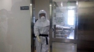 A health care worker in a full hazmat suit exits a patient&#39;s room at the Seoul Medical Center where eight people with MERS is being treated. 