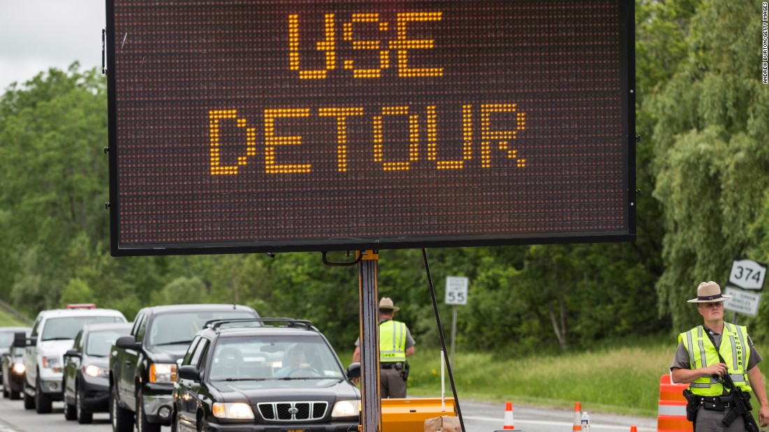 New York State Troopers stop civilian cars at a checkpoint outside 