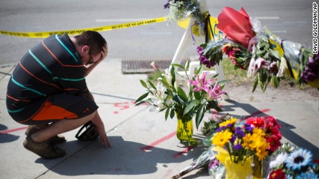 Charleston resident Noah Nicolaisen kneels at a makeshift memorial down the street from the church on June 18.