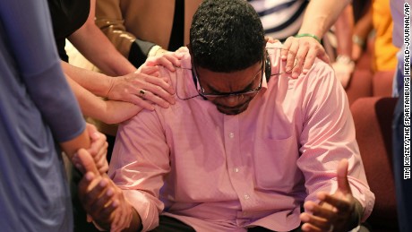 The Rev. Keith McDaniel, pastor of Macedonia Missionary Baptist Church, is surrounded by others in prayer on June 18 in Spartanburg, South Carolina. 