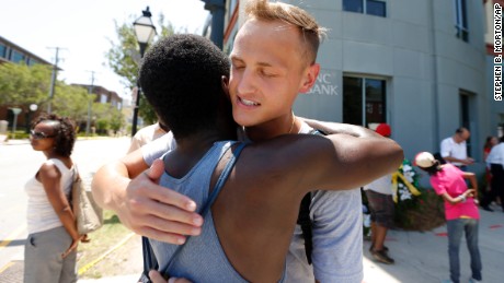 Tyler Francis, right, hugs Shondrey Dear after praying together June 18 at a makeshift memorial near the Emanuel AME Church. 