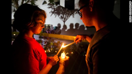 Olina Ortega, left, and Austin Gibbs light candles at a sidewalk memorial in front of Emanuel AME Church on June 18.