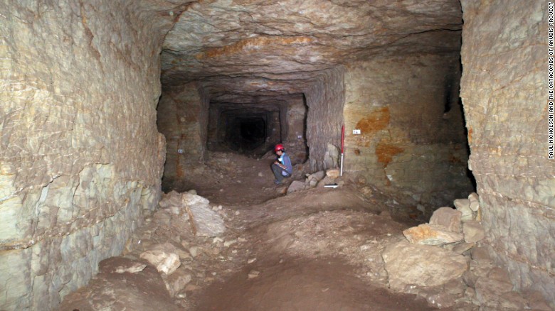 A member of the archaeological team sits inside the maze of burial tunnels in the catacombs of Anubis.