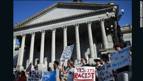 Protesters stand on the South Carolina State House steps during a rally to take down the Confederate flag, on Saturday, June 20, in Columbia. Police arrested Dylann Storm Roof, 2, in the slayings of <a href="http://www.cnn.com/2015/06/18/us/gallery/charleston-south-carolina-church-shooting/index.html" target="_blank">nine people </a>at a prayer meeting inside the Emanuel AME Church. 
