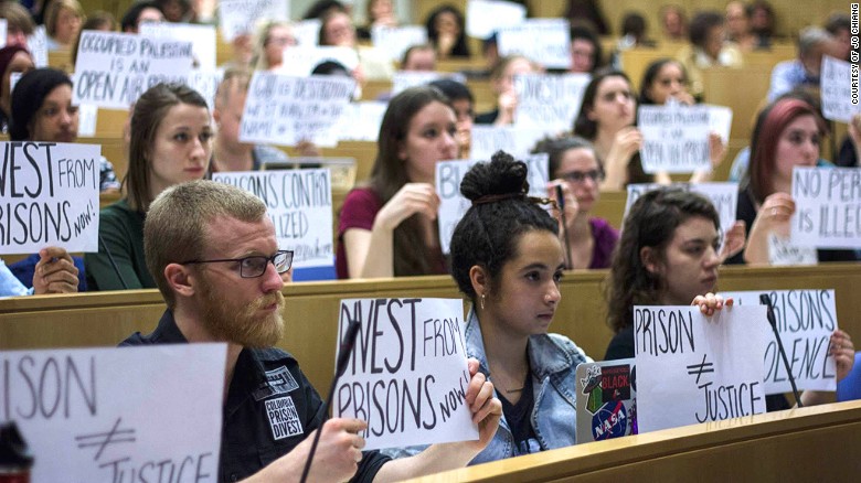 Members of Columbia Prison Divest hold protest signs at a University Senate meeting on April 2, 2015.
