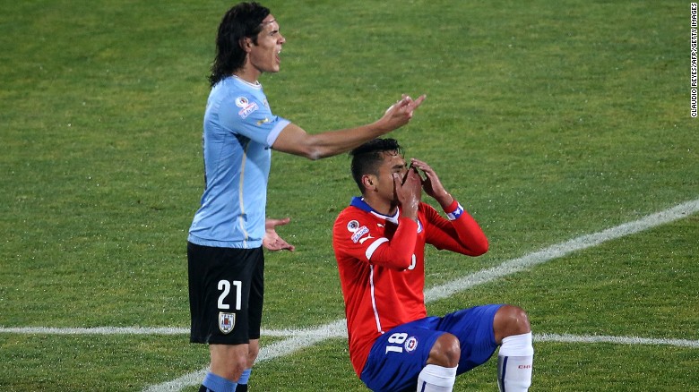 Gonzalo Jara falls to the floor after Edinson Cavani reacts to the Chilean&#39;s unwanted attention. The Uruguayan player was sent off after hitting the defender following his unusual action. Chile went on to win the 2015 Copa America quarterfinal 1-0. 